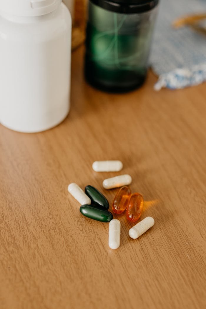 about-02 Assorted capsules and bottles on wooden table close-up.