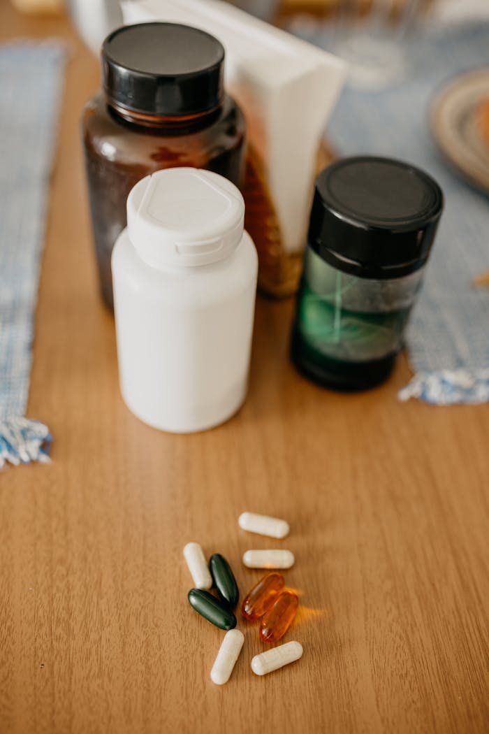 services-02 Assorted vitamin and supplement bottles with capsules on a wooden surface.