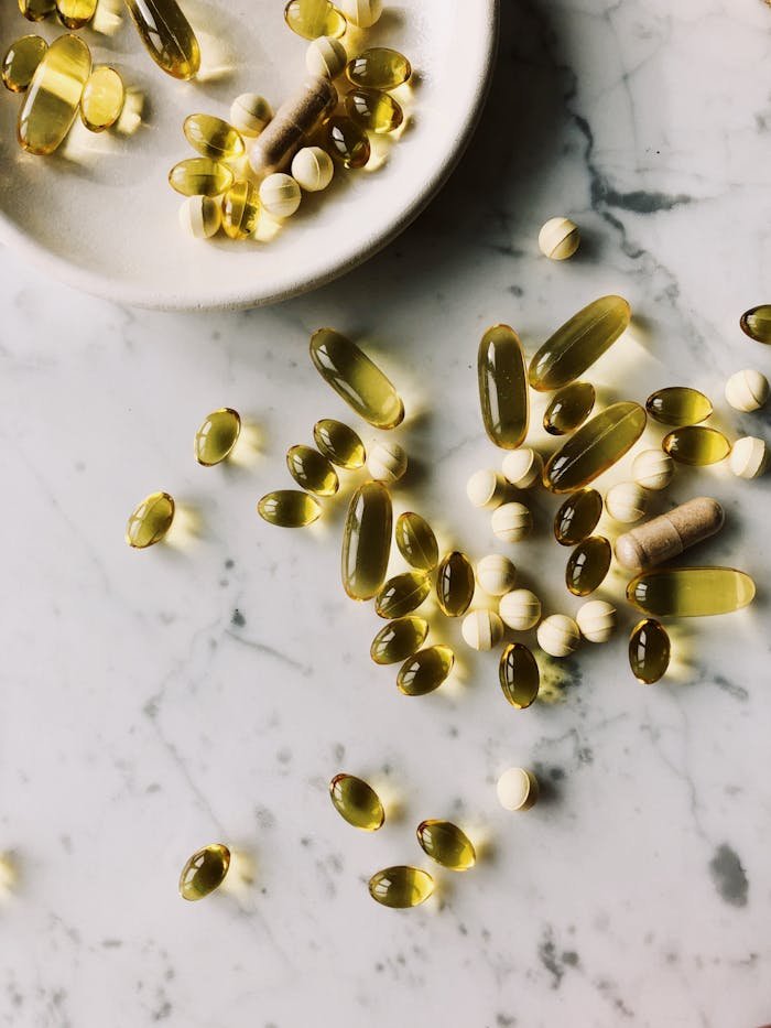 about-04 Scattered vitamins and supplements on a marble surface, highlighting healthcare and wellness.